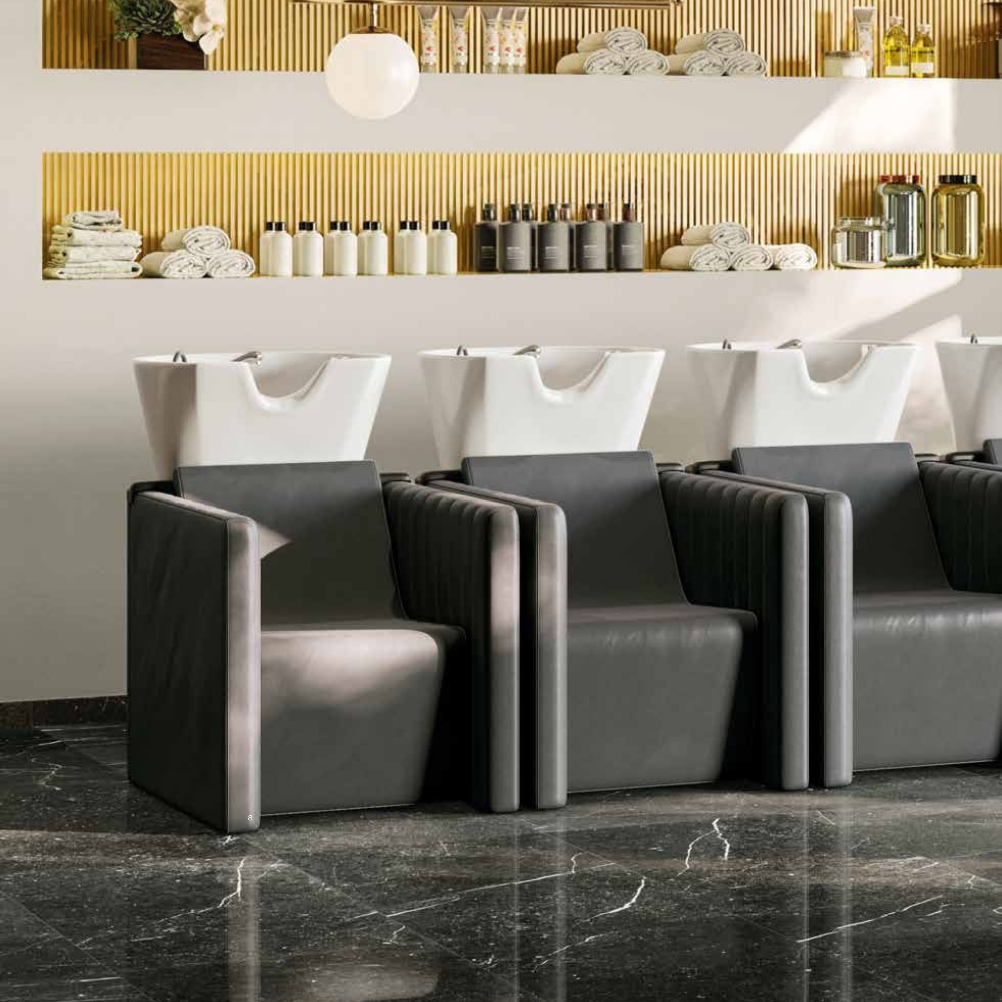 luksuzan frizerski salon s tri tamnosiva glavopera i bijelim umivaonicima, uz pozadinu sa zlatnim panelima i policama s ručnicima i proizvodima